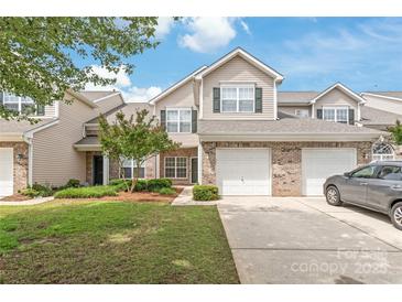 Charming townhouse with a well-maintained lawn, two-car garage, and a welcoming brick facade at 12452 Stratfield Place Cir, Pineville, NC 28134