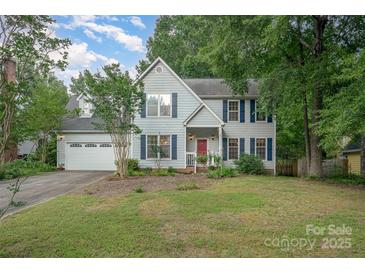 Charming two-story home with a well-manicured lawn, blue shutters, and a welcoming red front door at 13416 Kintyre Ct, Matthews, NC 28105