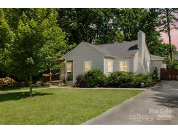 Charming single story home featuring a well-manicured lawn and lush trees providing shade and privacy at 3307 Draper Ave, Charlotte, NC 28205