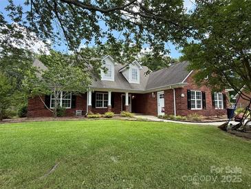 Beautiful brick home featuring a well-manicured lawn and mature trees for plenty of curb appeal at 4402 Poxon Ln, Monroe, NC 28110