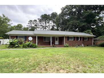 Charming brick home featuring a cozy covered porch and complemented by a beautifully landscaped front yard at 6539 Louglen Cir, Charlotte, NC 28212