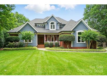 Charming two-story home with blue siding, brick accents, and a well-manicured lawn at 1042 Heather Glen Dr, Matthews, NC 28104