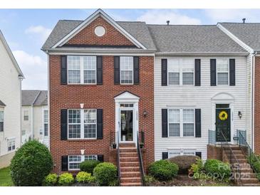 Charming two-story townhome featuring a classic brick facade, black shutters, and well-maintained landscaping at 12320 Verdant Ct, Charlotte, NC 28273