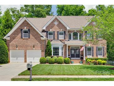 Charming brick home with a well-manicured lawn and a two-car garage, blending elegance with functionality at 1241 Brough Hall Dr, Waxhaw, NC 28173