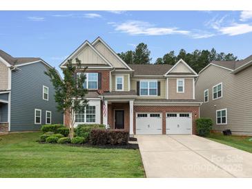 Charming two-story home with a manicured lawn, mature landscaping, and a two-car garage at 131 Cherry Bark Dr, Mooresville, NC 28117
