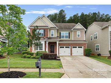 Charming two-story home with a well-manicured lawn and a two-car garage at 131 Cherry Bark Dr, Mooresville, NC 28117