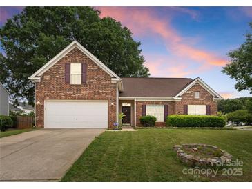Charming brick home featuring a well-manicured lawn, attached garage, and a warm, inviting entrance at 133 Fontanelle Dr, Mooresville, NC 28115