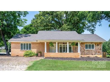 Charming single-story brick and stone home with welcoming front porch and lush landscaping at 318 W Peeler St, Salisbury, NC 28146