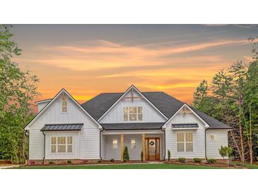 Stunning two-story home with white siding and a beautifully landscaped front yard at sunset at 4032 Brandy Creek Ct, Clover, SC 29710