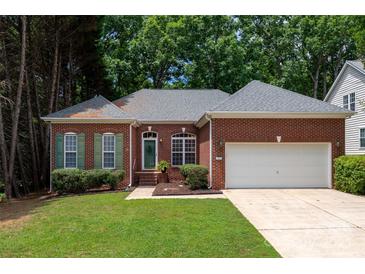 Charming brick home with lush green lawn, complemented by mature trees and a two-car garage at 8002 Kingston Dr, Waxhaw, NC 28173