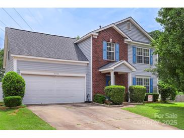 Charming two-story home with a brick facade, light grey siding, blue shutters, and a well-maintained front yard at 8904 Gerald Dr, Charlotte, NC 28217