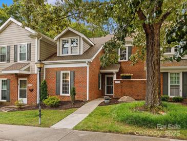 Charming brick townhome featuring a well-manicured lawn and inviting entrance at 9473 Kings Falls Dr, Charlotte, NC 28210