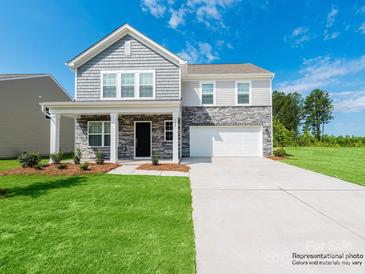 Two-story home with stone and gray siding, well-manicured lawn, and a two-car garage at 1531 River Cane St, Edgemoor, SC 29712