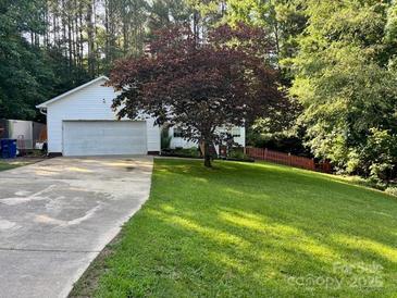 Charming home featuring a well-manicured lawn, mature tree, and an attached two-car garage at 1920 Waldeck Ct, Mount Pleasant, NC 28124