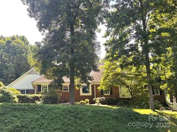 Charming brick home with mature trees and lush landscaping creating a serene and inviting curb appeal at 2020 Dawnshire Dr, Gastonia, NC 28054