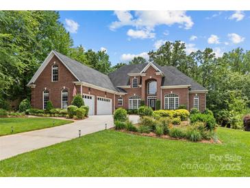 Stunning brick home featuring a three-car garage and beautiful landscaping at 4263 Rambling Rose Ln # 23, Rock Hill, SC 29732