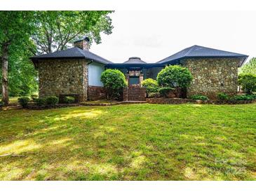 Charming stone-clad house featuring a lush front lawn, mature trees, and brick steps leading to the entrance at 4275 Herman Sipe Rd, Conover, NC 28613