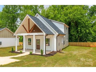 Charming home featuring a covered front porch with stylish beams and freshly landscaped yard at 512 North Mulberry St, Cherryville, NC 28021