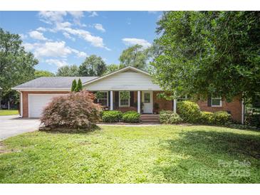 Charming brick home featuring a well-maintained lawn and welcoming front porch at 6300 Morehead Rd, Harrisburg, NC 28075