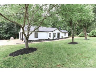 Beautiful house exterior with green lush lawn and trees, complemented by elegant landscaping around the foundation at 6310 Forney Hill Rd, Denver, NC 28037