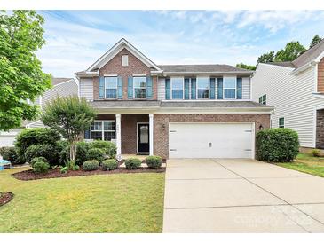 Two-story home featuring brick and gray siding, a two-car garage, well-maintained lawn and landscaped front yard at 6961 Liverpool Ct, Fort Mill, SC 29707