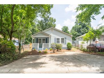 Charming home with a quaint front porch, a well-maintained yard, and a spacious driveway at 830 Mcarthur Ave, Charlotte, NC 28206