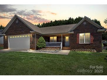 Charming brick home featuring an attached garage and inviting front porch at 1011 Atherstone Nw St, Conover, NC 28613