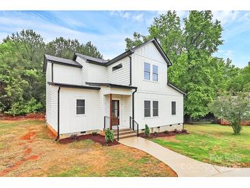 Charming two-story home featuring white siding, black accents, landscaped yard, and a welcoming walkway at 1011 Sandy Ct, Gastonia, NC 28056
