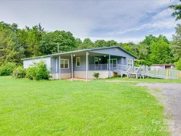 Charming single-story home with a covered porch and ramp access, set on a green lawn with surrounding trees at 1406 Old Puckett Pl # 14, York, SC 29745