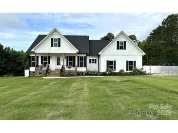 Charming two-story modern farmhouse with black shutters, covered porch, and a well-manicured lawn at 4282 Brandy Creek Ct, Clover, SC 29710