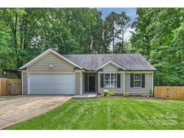 Charming single-story home with a well-manicured lawn, attached garage, and beautiful landscaping at 5179 Poplar Glen Dr, Matthews, NC 28104