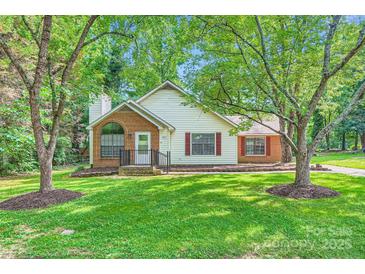Charming home with a brick and siding exterior, manicured lawn, and mature trees in a serene setting at 5817 Rocky Mount Ct, Charlotte, NC 28214