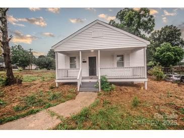 Charming home with a quaint front porch, freshly painted white exterior, and inviting curb appeal at 601 N Johnson St, Monroe, NC 28112
