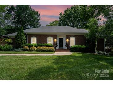 Charming one-story brick home featuring a beautifully landscaped yard and a welcoming front entrance at 935 Trentle Ct, Charlotte, NC 28211