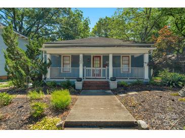 Charming single-story home with a covered porch, landscaped yard, and blue siding at 1500 Pecan Ave, Charlotte, NC 28205