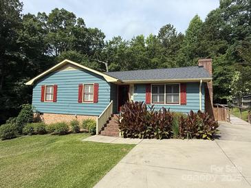 Charming one-story home featuring red shutters and manicured landscaping on a verdant, tree-lined lot at 200 Breslin St, Wadesboro, NC 28170