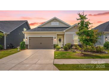 Charming home with a two-car garage, beautifully landscaped yard, and a welcoming front door with a wreath at 2473 Riparian Way, Denver, NC 28037