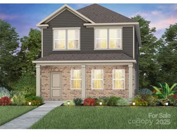 Charming two-story home featuring a brick facade, complemented by a well-manicured lawn and inviting landscaping at 3633 Edisto Pl # 118, Monroe, NC 28110