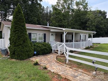 Charming home featuring a welcoming front porch, stone walkway, and a well-manicured lawn at 7010 Executive Cir, Denver, NC 28037