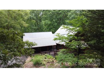 Charming log home with a metal roof, front porch, and lush greenery surrounding the property at 720 Potneck Rd, Salisbury, NC 28147