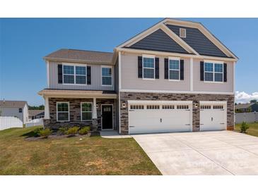 Charming two-story home with a three car garage, gray siding and beautiful stone accents at 9529 Cotswood Pl, Gastonia, NC 28056