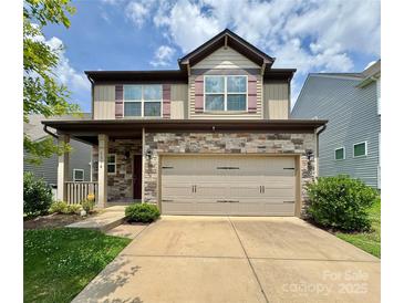Two-story home featuring a stone facade, a two-car garage, a manicured lawn, and a welcoming covered front porch at 1314 San Gabriel Ave, Charlotte, NC 28214