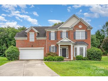 Charming two-story brick home with a well-manicured lawn and a two-car garage at 14911 Taggert Trail Dr, Charlotte, NC 28273