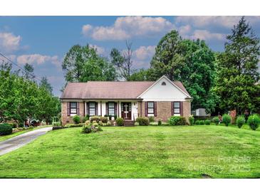 Charming single story brick home with a well-manicured lawn and mature trees at 1658 Buckingham Ave, Gastonia, NC 28054
