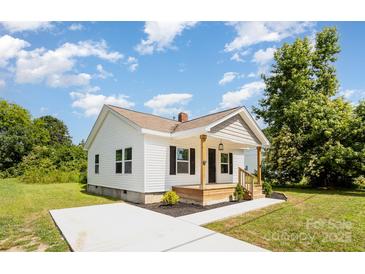 Charming single-story home with white siding, a welcoming front porch, and a freshly poured concrete driveway at 210 Marshall St, Rock Hill, SC 29730