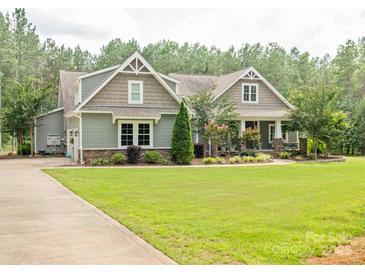 Charming two-story home featuring manicured lawn, lush landscaping, and inviting curb appeal in a wooded neighborhood at 237 Garvin Rd, McConnells, SC 29726