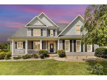 Charming two-story home featuring a covered front porch and professionally landscaped yard at 3068 Green Acres Ln, Claremont, NC 28610