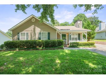 Charming single-story home with well-manicured lawn and cozy front porch with white picket fence at 322 Cottonwood Park Dr, Charlotte, NC 28214