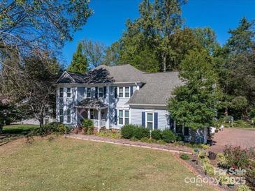 Charming two-story home with a well-manicured front yard and beautiful mature trees at 3664 Gaston Day School Rd, Gastonia, NC 28056