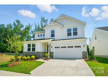 Charming two-story home featuring white siding, stone accents, manicured landscaping, and an attached two-car garage at 9846 Quercus Ln, Huntersville, NC 28078